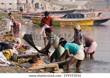 VARANASI, INDIA - DECEMBER 1, 2012: Unidentified Indian people wash clothes in Ganga river in Varanasi, India. For many dwellers of Varanasi the Ganga is only way to wash clothes.