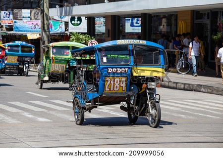 DUMAGUETE, PHILIPPINES - FEBRUARY 18, 2014 :Tricycle motor taxi, Philippines inexpensive transport service. Tricycle motor taxi are the most popular means of public transportation in the Philippines.