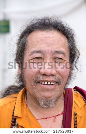 DHARAMSALA, INDIA - SEPTEMBER 25 2014: Old unidentified Tibetan Buddhist monk in the Dharamsala near Dalai Lama\'s residence.