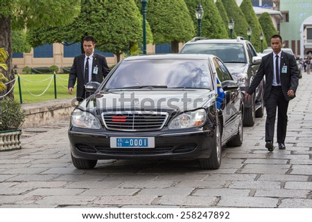 BANGKOK, THAILAND - NOVEMBER 17, 2013 : An unidentified body guards protect state automobile, which moves in the Grand Palace in Bangkok.