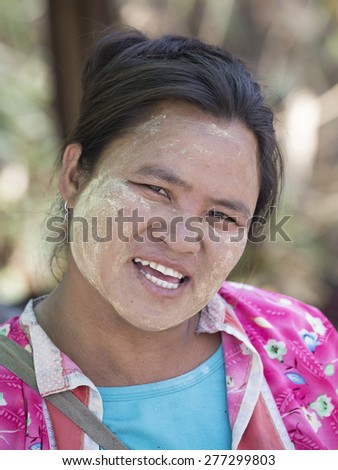 MAE HONG SONG, THAILAND - APRIL 13, 2015 : Portrait Myanmar woman with thanaka on her smile face is happiness. Thanaka is a yellowish-white cosmetic paste made from ground bark.