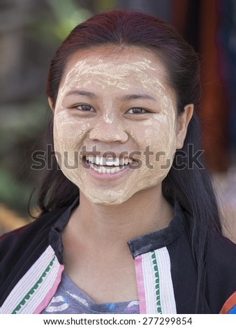 MAE HONG SONG, THAILAND - APRIL 13, 2015 : Portrait Myanmar woman with thanaka on her smile face is happiness. Thanaka is a yellowish-white cosmetic paste made from ground bark.