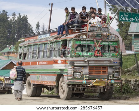 SRINAGAR, INDIA - JUNE 07, 2015: Local bus in indian inexpensive bus service. Local residents ride on the roof of the bus