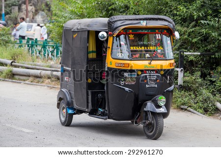 SRINAGAR, INDIA - JULE 02, 2015: Auto rickshaw taxis on a road in Kashmir, India. These iconic taxis have recently been fitted with CNG powered engines in an effort to reduce pollution