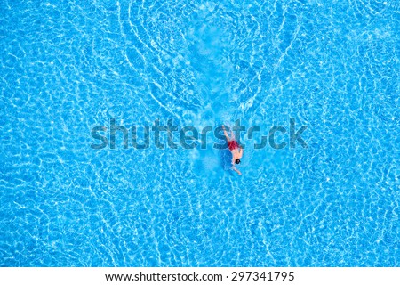 Man swim in the pool at the hotel. View from above.