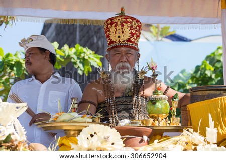 UBUD, BALI, INDONESIA - MARCH 19, 2015 : Unidentified Indonesian people celebrate Balinese New Year and the arrival of spring. Old Brahmin conducts religious ritual on the beach Ketewel