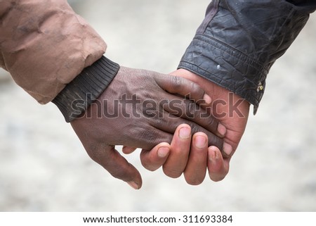 Couple hands  on the street in India, close up. In India, it is normal to go to men holding each other by the hand
