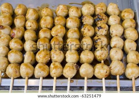Meatballs on sticks, dipped in sweet chili sauce at a market in Thailand