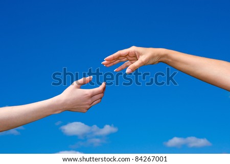 Hand reaching out from the blue sky