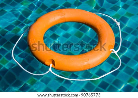 Life ring floating on top of sunny blue water
