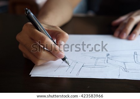Hand of Designer with a pen, designing and sketching his idea