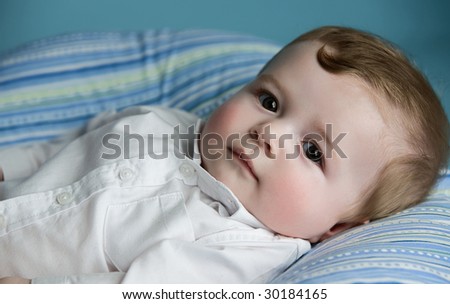 baby boy lying on pillow