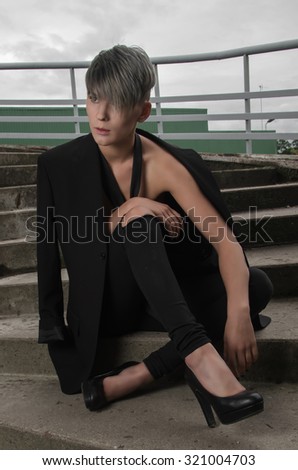 Young woman model in manly style wearing in suit and tie without shirt.