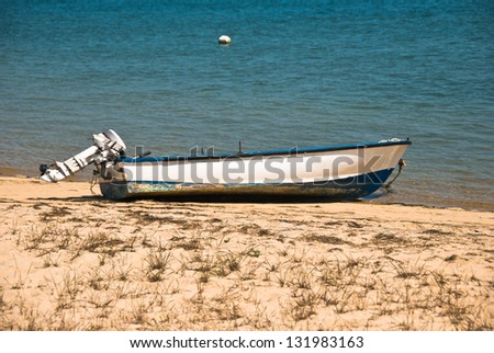 Small Boat with Outboard Motor on a Beach