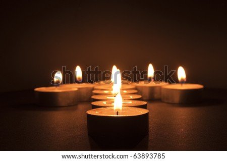 Tea Candles in the shape of an Arrow on A Black Background