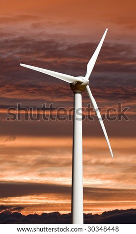 A wind turbine used for electricity generation against sunset sky.