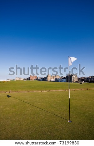 The flag on the first hole of the famous Old Course links in St Andrews on a clear sunny afternoon.