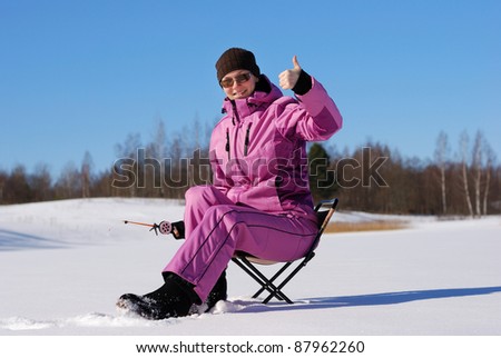 Young attractive girl on winter fishing
