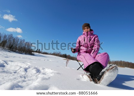 Young attractive girl on winter fishing