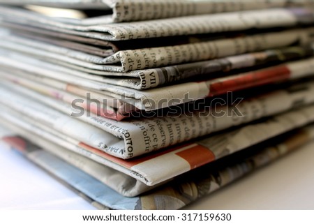 Newspapers\
This is a photograph of newspapers stacked one on the other