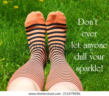 Inspirational quote about individuality by an unknown author with a teenaged girl\'s legs with crazy socks laying on the grass in summer.