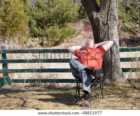 A middle aged man sits back and enjoys the sun after a long cold winter in the Spring.