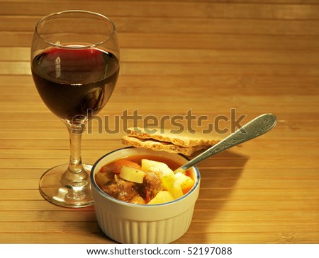Spicy potato and sausage soup with red wine and crackers.