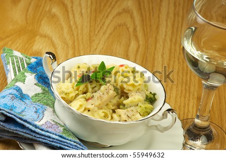 A single serving of delicious hot chicken caesar and pasta with broccoli and red peppers in a creamy Parmesan sauce.