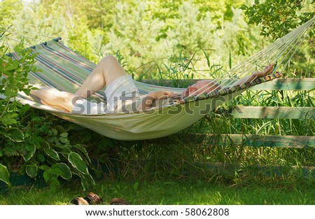 Middle aged man relaxing in a hammock in the shade on a hot summer day.