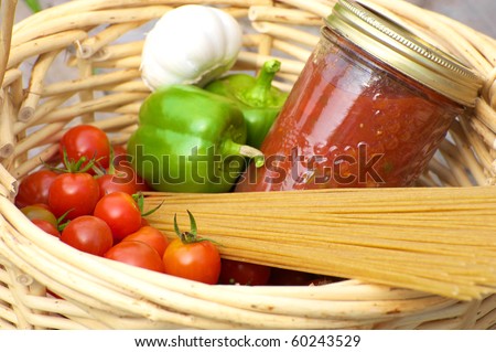 Basket of freshly picked organic vegetables, homemade pasta sauce and raw whole wheat pasta.