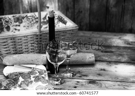 Country picnic for two with wine, bread and cheese, desaturated.