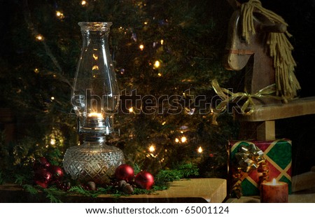 Christmas scene featuring a lit oil lamp on a table in front of a Christmas tree with sparkling lights and a toy wooden pony.  Grunge textured.