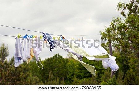 Clothes and towels drying on a rural clothesline on a windy, cloudy summer afternoon.