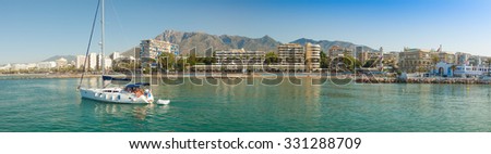 A sailing yacht leaves the port at Marina Marbella. A panoramic view of this beautiful marina on the Costa del Sol, Spain
