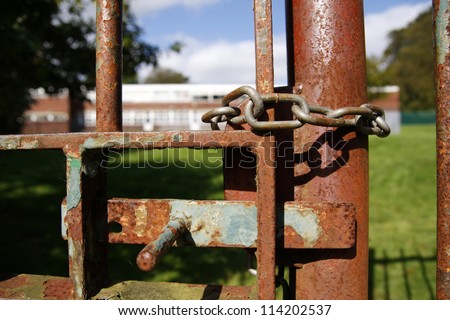 Rusty school gate chained and locked