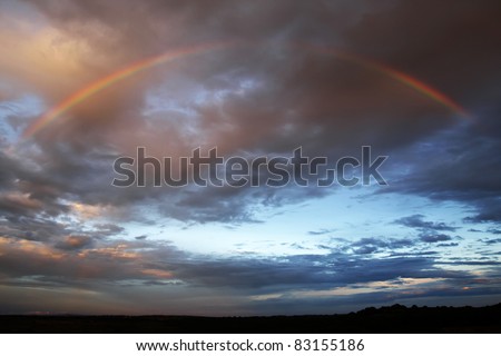Rainbow against a dark sky at sunset