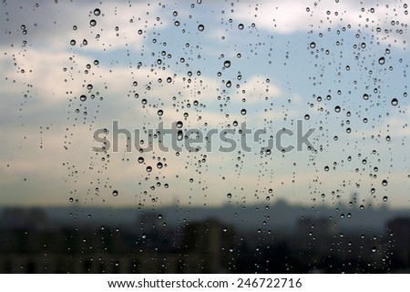Raindrops on a window against a skyline of the city