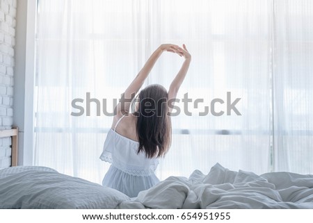 Happy woman wake up on her bed in the morning.