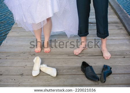 Front view of wedding couple\'s feet standing on the wooden bridge.