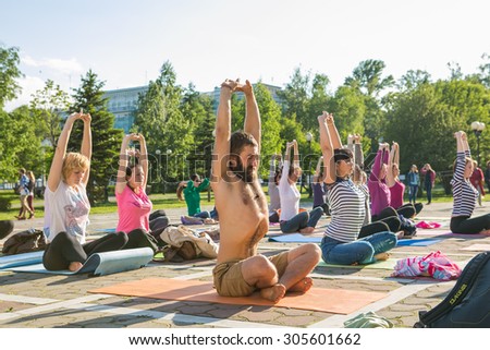 Novokuznetsk, Kemerovo region, Russia - 06 June 2014: People participating in the free public Yoga class in summer at Park, Novokuznetsk, 06 June 2014.