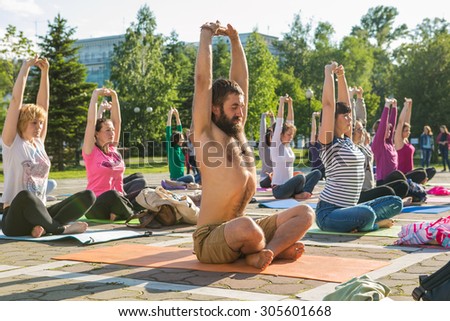 Novokuznetsk, Kemerovo region, Russia - 06 June 2014: People participating in the free public Yoga class in summer at Park, Novokuznetsk, 06 June 2014.
