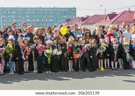NOVOKUZNETSK, KEMEROVO REGION, RUSSIA - SEPTEMBER, 1, 2014: Meeting with the first-grade pupils and teacher at schoolyard. The day of knowledge in Russia.