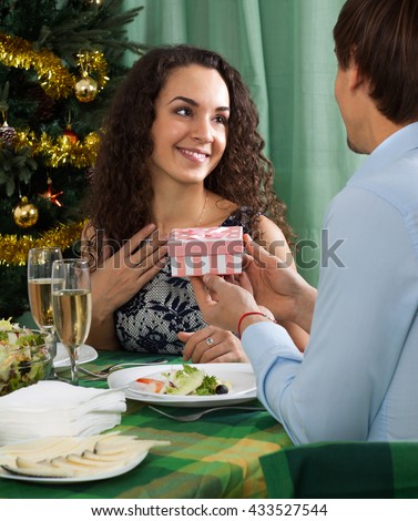 Man giving present to female during dinner in home