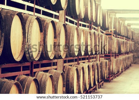storage with row of aged wooden wine barrels