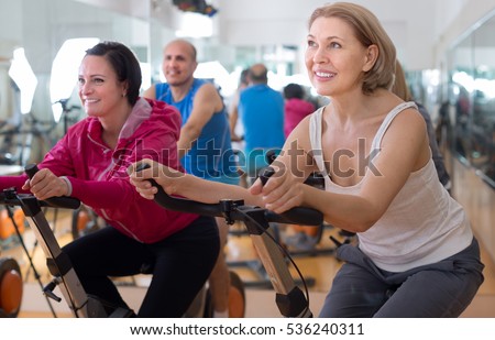 satisfied older people do sports on exercise bikes