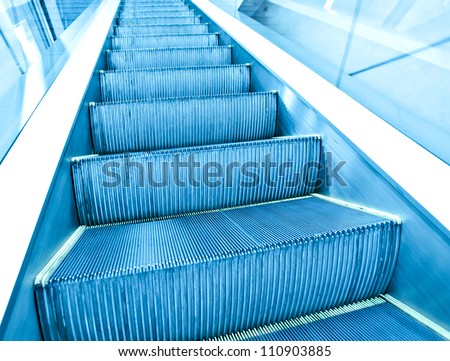 contemporary moving escalator stairs inside business blue hall