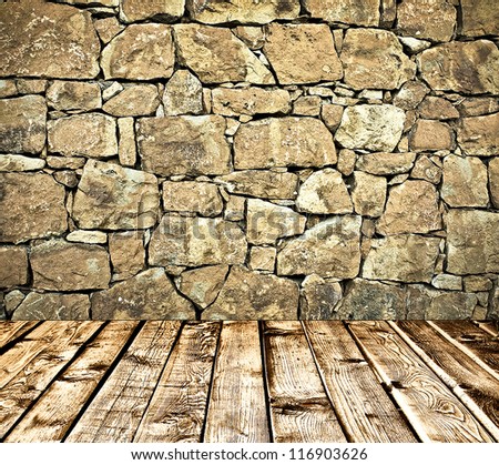 Empty old spacious room with stone grungy wall and wooden weathered dirty floor, vintage background texture of brickwall