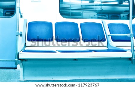 Contemporary light blue illuminated carriage interior with nobody of people inside underground metro station