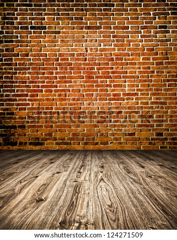 Empty red old spacious room with stone grungy wall and wooden weathered dirty floor, vintage background texture of brickwall