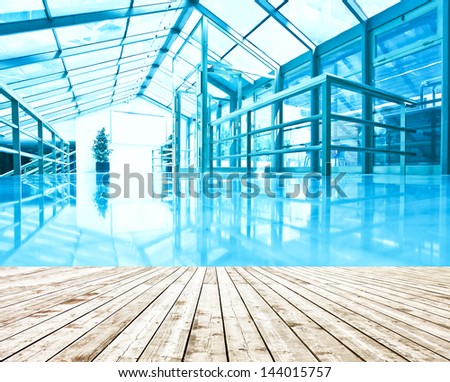 Underside wide angled and perspective view to steel blue glass airport ceiling through high rise building skyscrapers, business concept of successful industrial architecture  with wooden planks floor